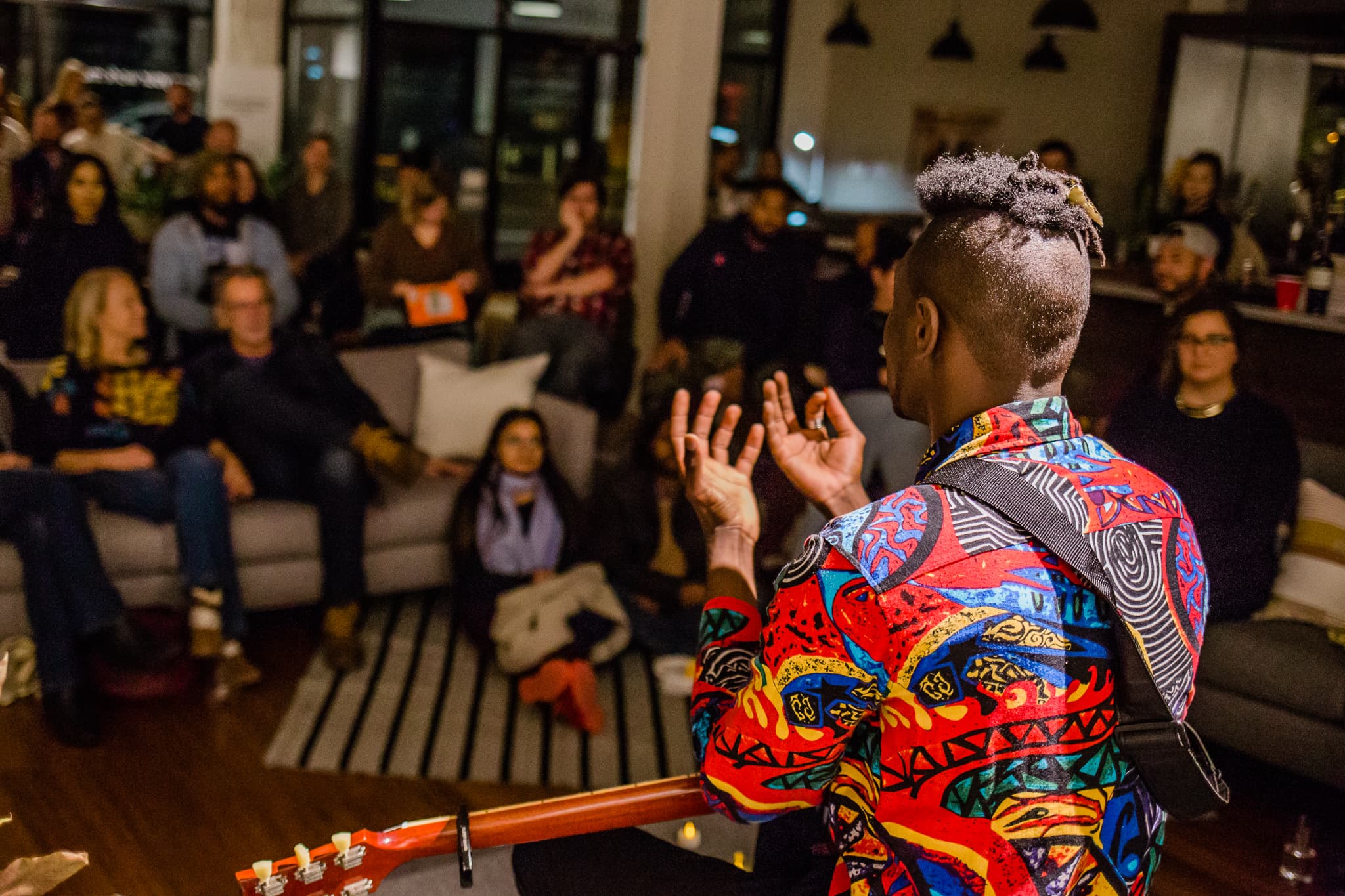 Bisi performing for a seated audience at an evening event
