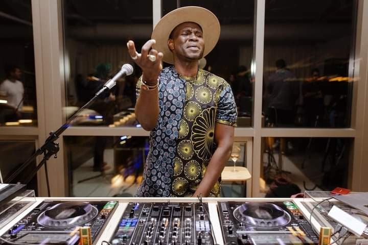 Bisi DJing behind the decks at a venue